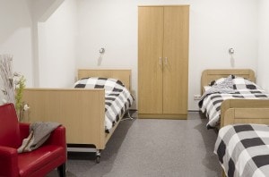 Slaapkamer met 3 bedden, stoel en kast groepsaccommodatie De Leilinde